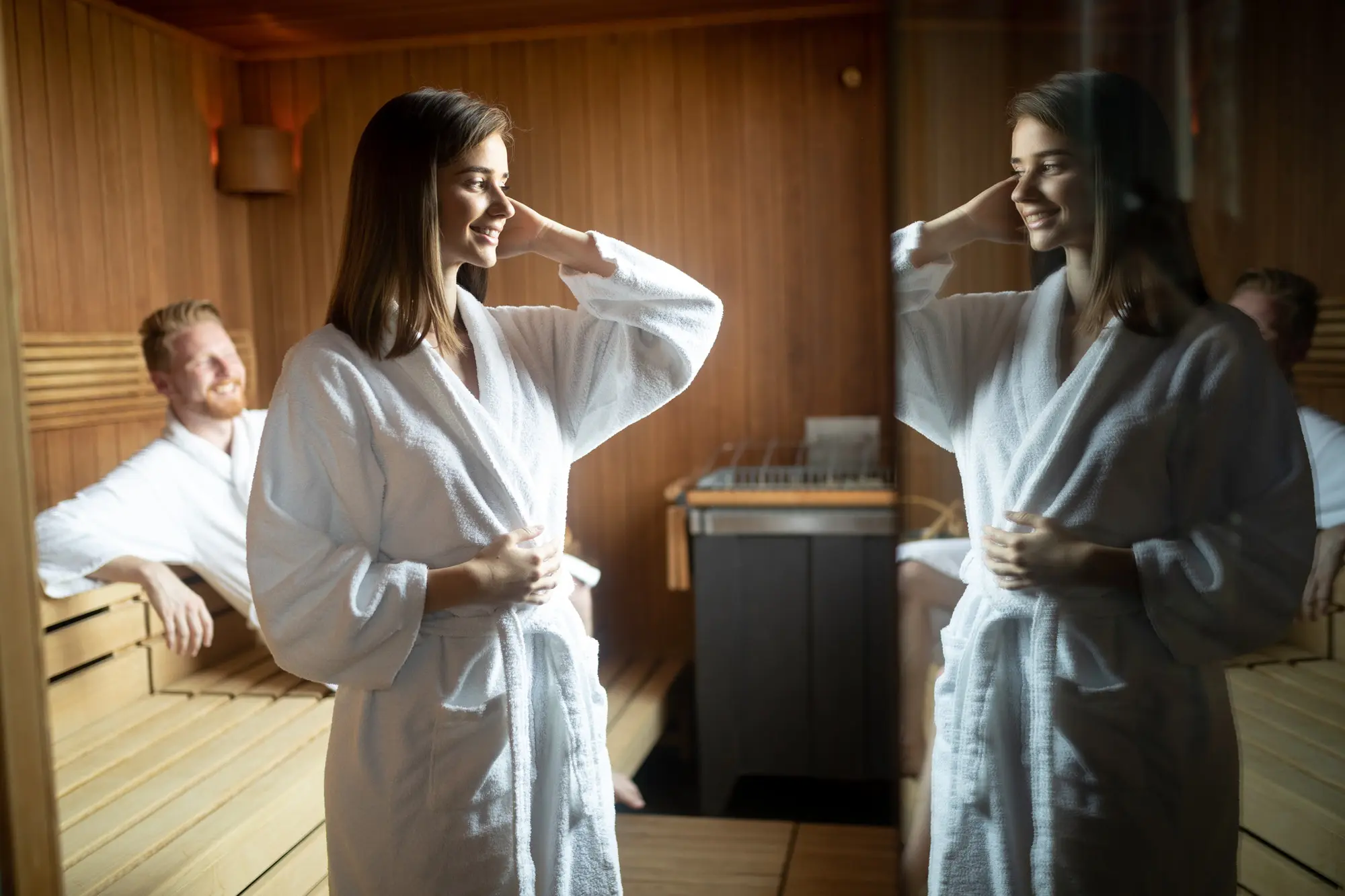 Attractive man and beautiful woman relaxing together in sauna
